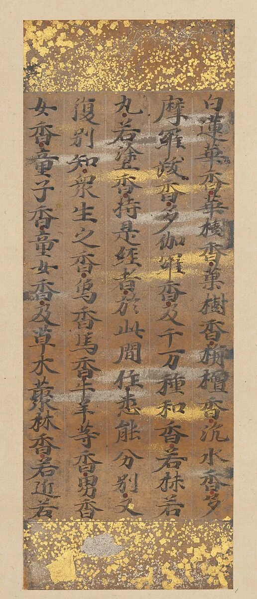 Langes, schmales Papierfeld mit dunklen senkrechten Schriftspalten sowie aufgestreuten Goldstückchen und goldenen Bändern.