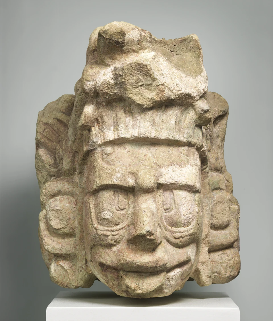 Historischer Maya-Kopf einer Sonnengestalt, mit deutlichen Gesichtszügen und plastischen Details.