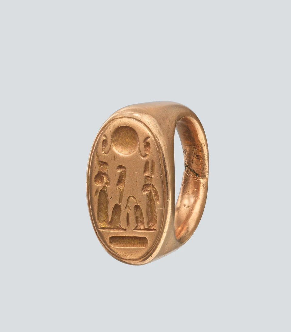 Goldener Siegelring mit kleinen eingetieften Figuren und Zeichen; das Foto selbst sichert keine Darstellung von Schu oder Tefnut.