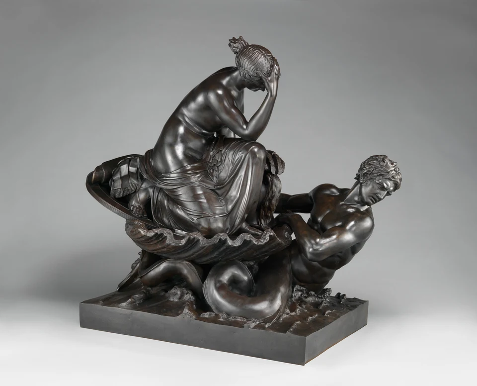 Dunkle Skulptur: eine sitzende Frau auf einer schalenartigen Form und eine kräftige Meeresgestalt, die sie zieht.