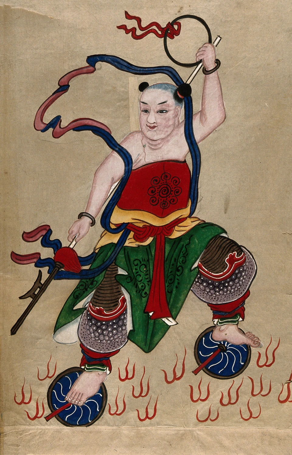 Kindliche Nezha-Figur mit Ring, Lanze und wehenden Bändern, auf zwei blauen Rädern zwischen roten Flammen.