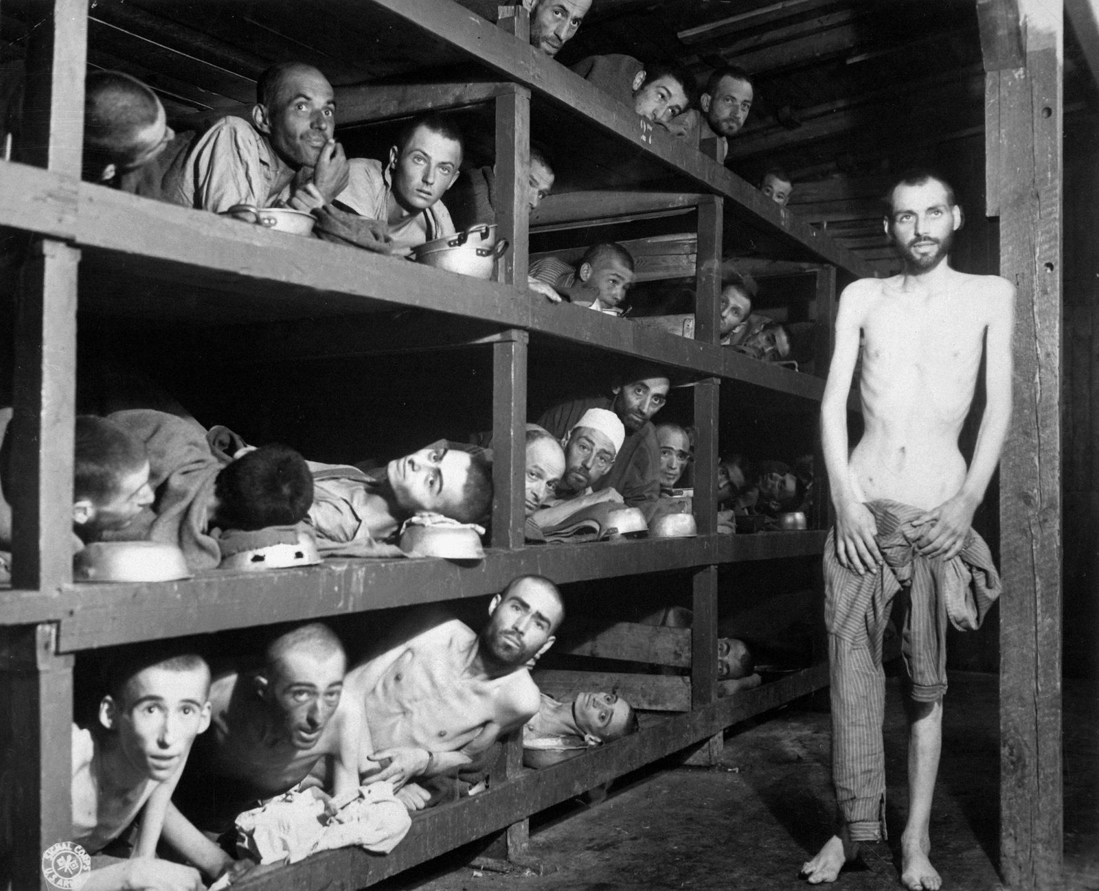 Ausgezehrte Überlebende in mehrstöckigen Holzpritschen einer Baracke des befreiten Konzentrationslagers Buchenwald.