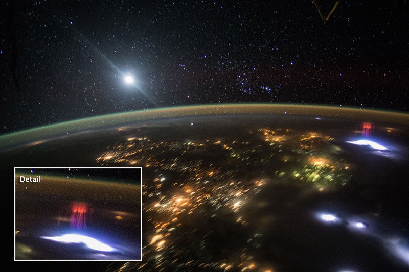 Dokumentarisches ISS-Foto: ein kleiner roter Sprite rechts über einem hellen Gewitter, links unten ein bereits von der Quelle eingefügter vergrößerter Ausschnitt.