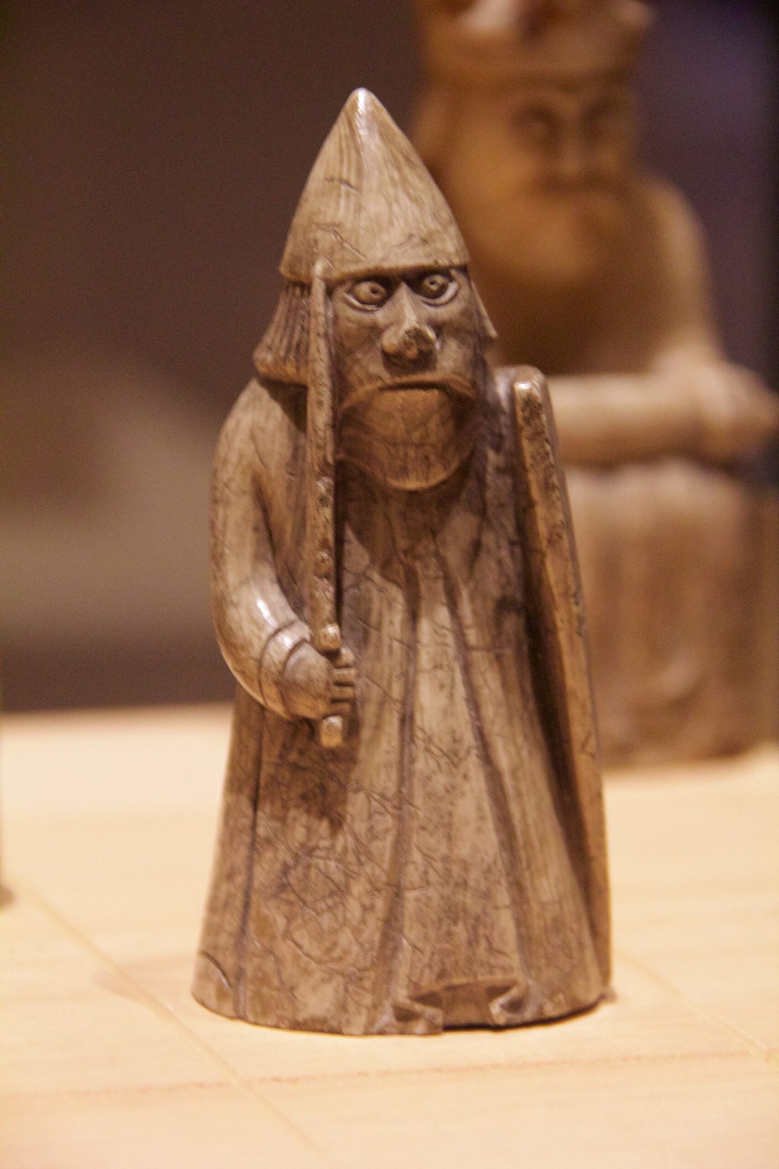 Eine Lewis-Schachfigur im National Museum of Scotland: stehender Krieger mit spitzem Helm, Schwert und seitlichem Schild; Aufnahme 2013.